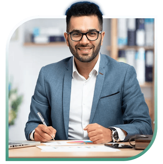 A finance professional smiling while working at a desk