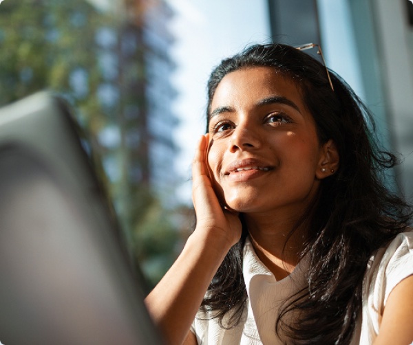 A student smiling while studying on a laptop